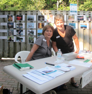 Cheryl Andrews and Cathy Morrison, ORLA registration desk with photo finalist behind